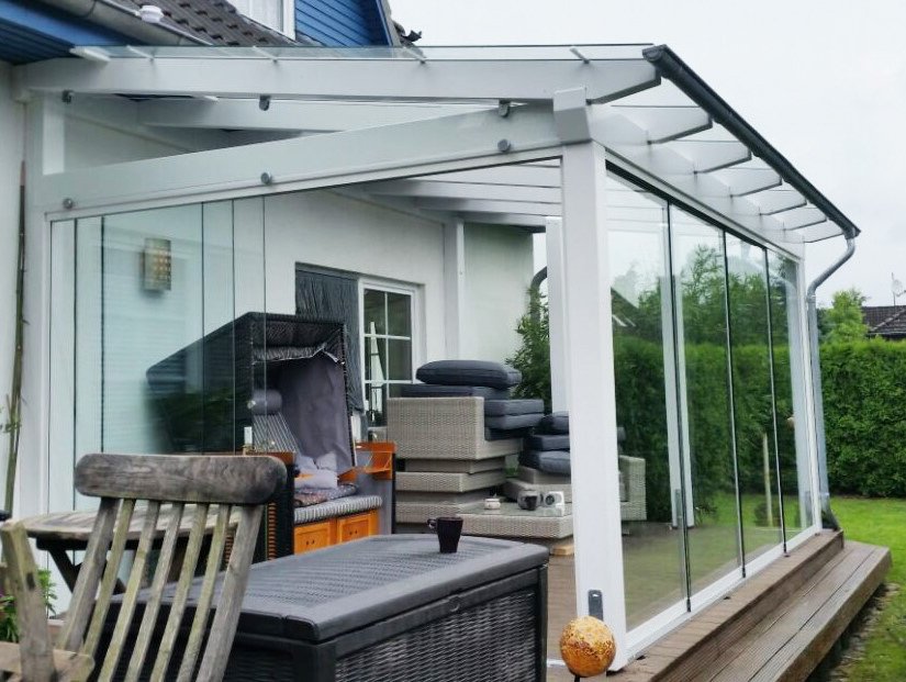 Terrassenüberdachung mit Glasschiebetüren für Windschutz und Offenheit Terrassenüberdachung mit Glasschiebetüren für Windschutz und Offenheit